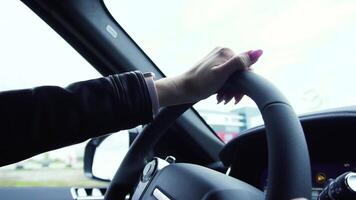 ung företag kvinna förare körning en bil på en motorväg. stock. stänga upp ung skön kvinna körning en lyx bil på väg video