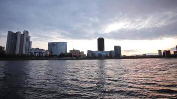 Jekaterinburg Stadt Center auf Sonnenuntergang. Stadt Teich Sicht, tolle Wolken und Himmel. hoch Gebäude, Wolkenkratzer auf das Damm von das Fluss ich setze. video