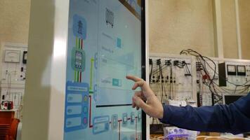 Man works on a touch screen. Young scientist uses a large touch screen to work video