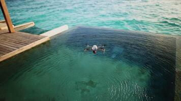 A drone flies over a swimming pool in the Maldives video