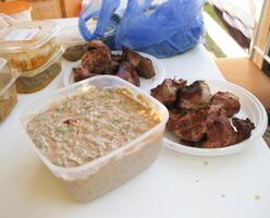 Shish kebab in disposable dishes. Fried meat in plastic plates. photo