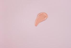 close-up of a smear of foundation on a pink background. photo