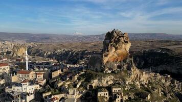 aéreo zumbido ver de el ortahisar castillo en capadocia, Turquía con el nieve tapado montar erciyes en el antecedentes. personas disfrutando el ver desde el parte superior de el castillo. video