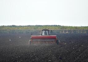 Tractor with seeder in the field photo