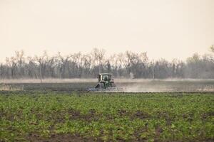 Tractor plowing the soil processes photo
