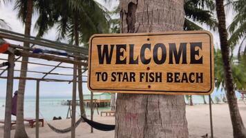Welcome signboard at Star Fish Beach with scenic tropical backdrop, suggesting vacation and travel themes for holiday stock footage video