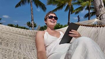 Relaxed Woman with Tablet in Tropical Hammock video