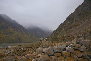 Cloudy foggy sky, mountain peaks covered with fog in the morning. Caucasus Mountains, Upper Balkaria, Russia. photo