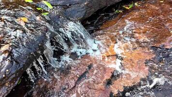 vibrerande naturlig vattenfall över färgrik stenar video