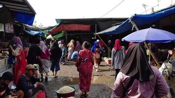 lombok, Indonesia - 31 dicembre 2023. fangoso strada atmosfera dopo pioggia nel un' tradizionale mercato con denso e occupato attività video