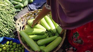 ett indonesiska kvinna välja päron på en traditionell marknadsföra, handla på en lokal- marknadsföra, stänga upp se, 4k upplösning. video