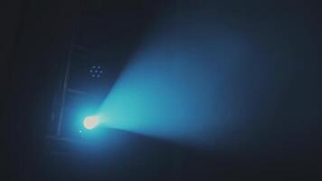 The blue light from the spotlights through the smoke in the theatre during the performance. Lighting equipment. video
