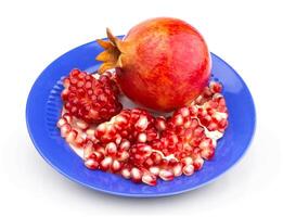 Pomegranate on plate isolated on white background photo