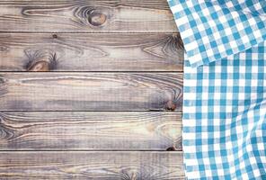 White old wooden table with blue checkered tablecloth, top view with copy space photo
