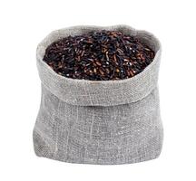 Black rice in burlap bag isolated on white photo