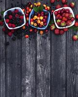 Fresh forest berries on wooden background photo