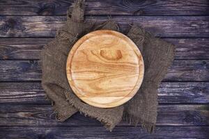 Round tray for pizza on dark wooden table. Top view. Copy space. photo