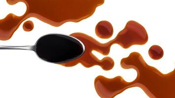 Spilled soy sauce with spoon isolated on white background photo