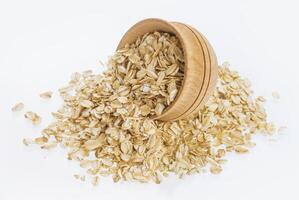 Oat flakes in wooden bowl isolated on white background photo