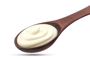 Sour cream in wooden spoon isolated on white background photo