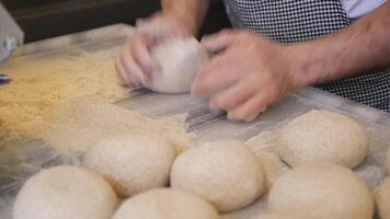 handen het formulier stukken van deeg voor bakken brood en broodjes. video