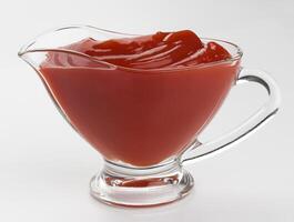 Glass bowl of ketchup isolated on white background photo