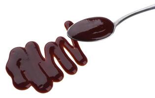 Barbecue sauce. Splashes and spilled grill sauce with spoon isolated on white background photo