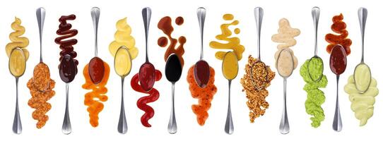 Set of different sauces with spoons isolated on white background photo