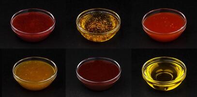 Different sauces isolated on black background photo