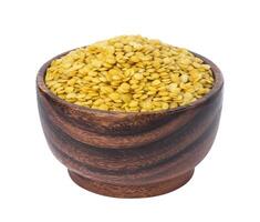 Yellow lentils in wooden bowl isolated on white background photo