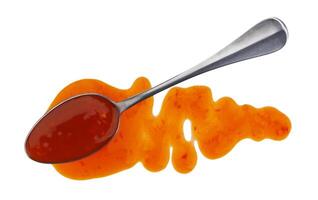 Sweet and sour sauce with spoon isolated on white background. Top view photo