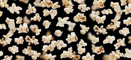 Flying popcorn isolated on black background photo