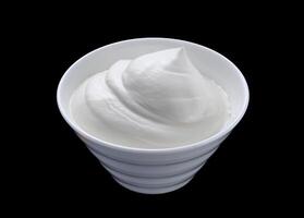 Sour cream in white bowl isolated on black background photo