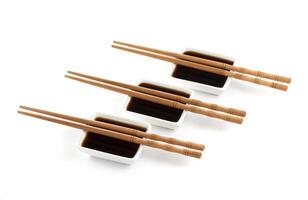 Soy sauce and chopsticks isolated on white photo