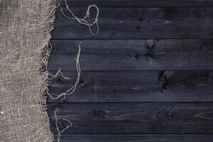 Black wooden table with burlap tablecloth, top view photo