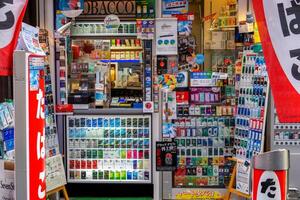 Osaka City, Japan, 2023 - Closeup front of small Japanese cigarette shop with fully and variety cigarette on shelves. Cold weather and work stress thus making Japanese people more in smoking. photo