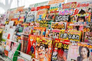 Osaka City, Japan, 2023 -Colors and beauty Eye-catching with various of Japanese book and magazine on shelf in book shop and mini mart in Japan. photo