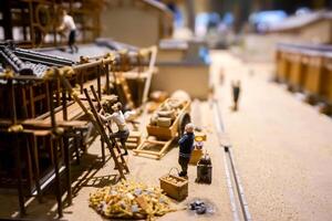 Osaka City, Japan, 2023 - Closeup miniature models and toys of Japanese worker building a house of the 1800's ancient in urban on blurry background. photo