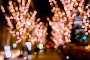 Blurred and bokeh of pink LED refection lighting decorate on trees in Valentines day with city night life in Osaka, Japan. photo