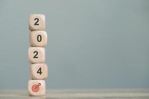 wood cube block with return on investment in stocks, crypto coins in 2024, growing according to target photo