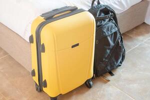 yellow suitcase on white wall background in hotel room photo