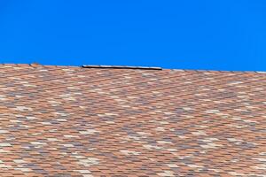 Roof from multi-colored bituminous shingles. Patterned bitumen shingles. photo