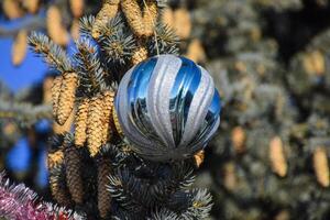 decoraciones nuevo año árbol. oropel y juguetes, pelotas y otro decoraciones en el Navidad Navidad árbol en pie en el abierto aire. foto