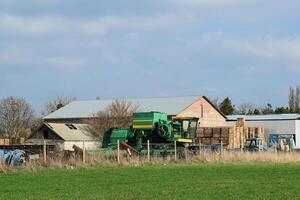 Old tractor and harvester in a brick shed. Store the old equipment photo