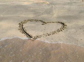 Heart drawn on the beach sand photo