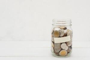 Thai Baht coins in a glass jar. Business and finance concept. photo