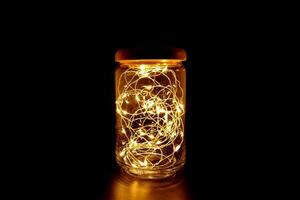 Fairy Light in a Glass Jar with Wooden Lid, in the Dark. Low-Key Photography. photo