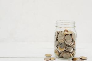 Thai Baht coins in a glass jar. Business and finance concept. photo