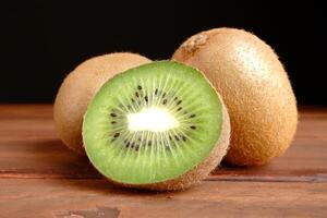 Fresh Kiwi on Wooden Table with Dark Background photo