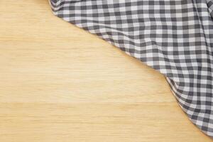 Wrinkled grey gingham fabric on rustic  wood plank background, with copy space. photo